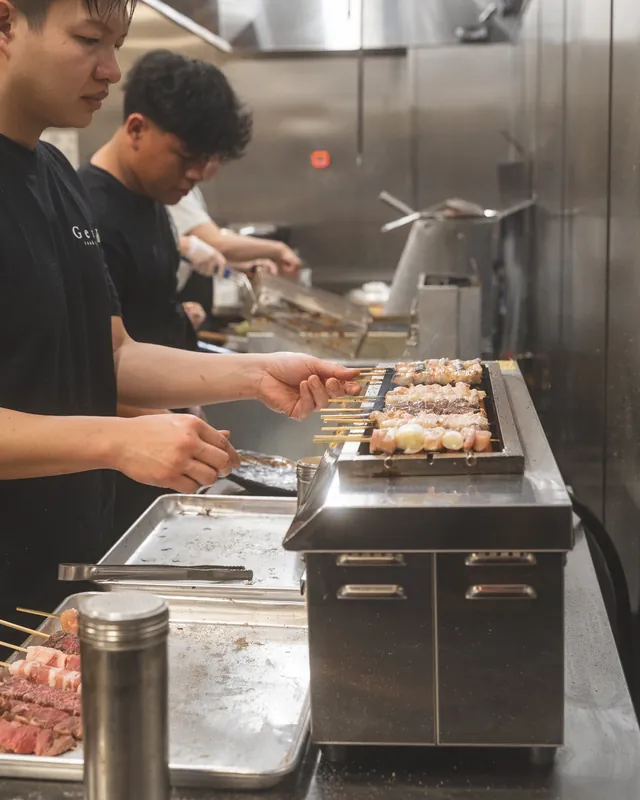 Genki’s cooks tending rows of skewers in the kitchen