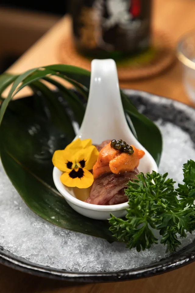 Wagyu and uni served on a ceramic spoon over ice